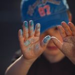 Child Creativity - person in blue and white shirt covering face with hands