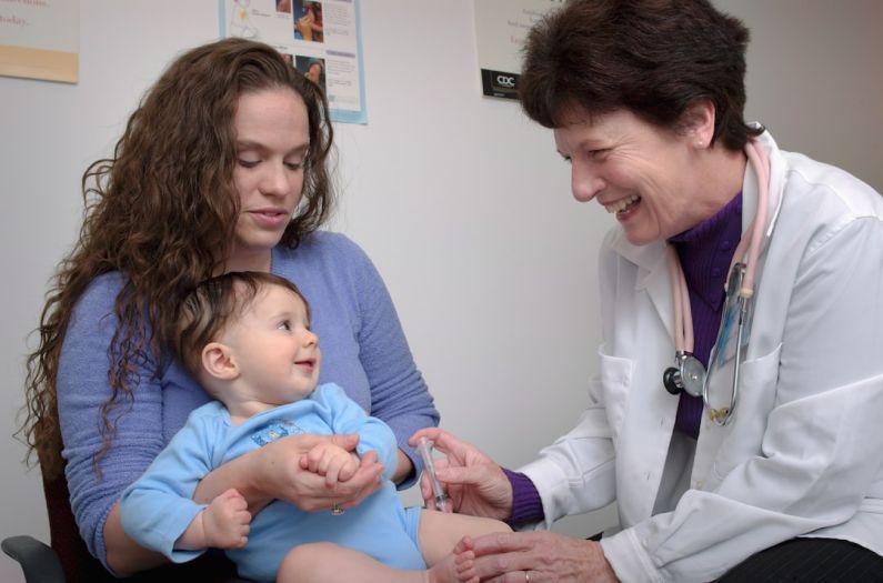 Pediatrician - a young child is being examined by a doctor