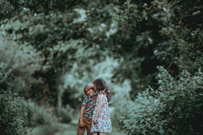 Sibling Rivalry - boy and girl standing in middle of forest trail