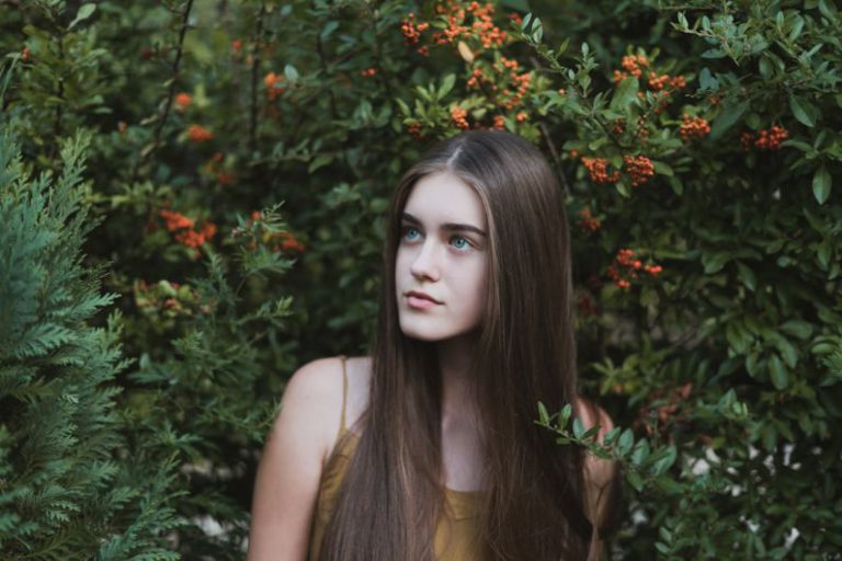 Teenage Behavior - woman standing next to red flower