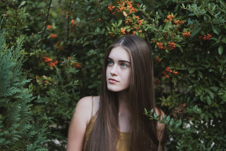 Teenage Behavior - woman standing next to red flower
