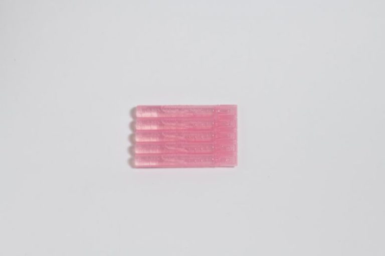Plastic Reduction - three pink toothbrushes on a white surface
