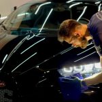 Car Detailing - man in blue crew neck t-shirt standing beside black car