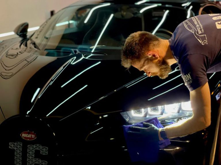 Car Detailing - man in blue crew neck t-shirt standing beside black car