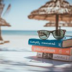 Vacation Planning - black framed Ray-Ban Wayfarer sunglasses on top of book