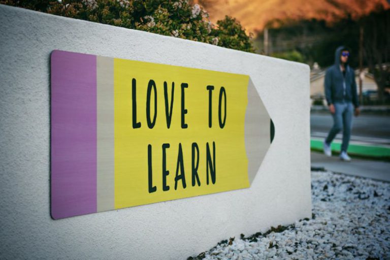 Language Learning - love to learn pencil signage on wall near walking man