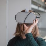 VR Technology - woman in black sweater holding white and black vr goggles