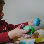 Art Project - boy holding blue and green painted egg shells