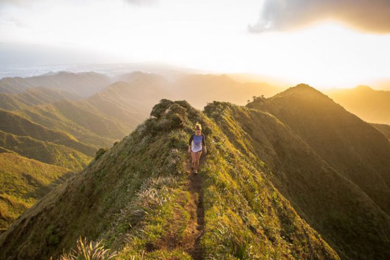 Hiking Beginners - woman walking on pathway on top of hill at golden hour