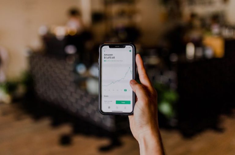 Fintech Trends - person holding black iPhone displaying stock exchange
