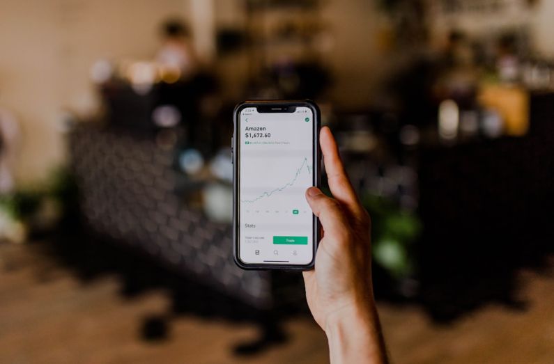 Fintech Trends - person holding black iPhone displaying stock exchange