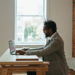 Home Office - a person sitting at a desk with a laptop and papers