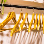 Home Declutter - a rack of clothes hanging on a wall