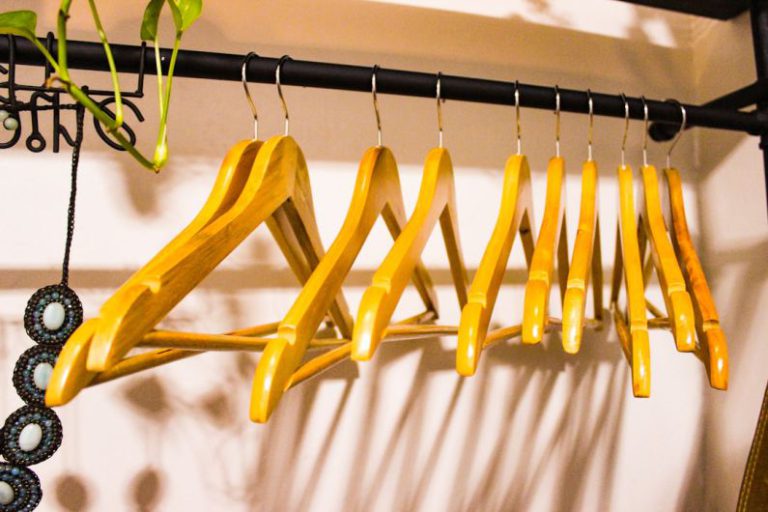 Home Declutter - a rack of clothes hanging on a wall