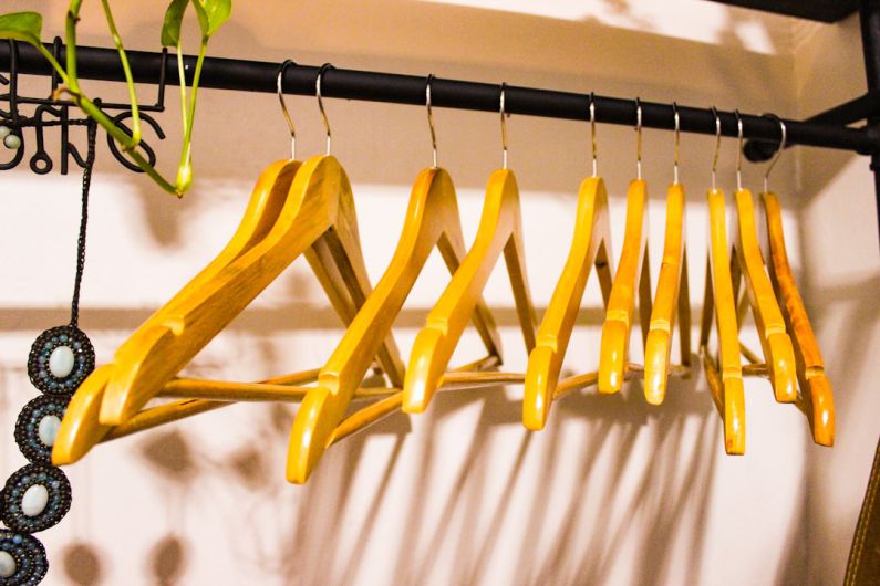 Home Declutter - a rack of clothes hanging on a wall