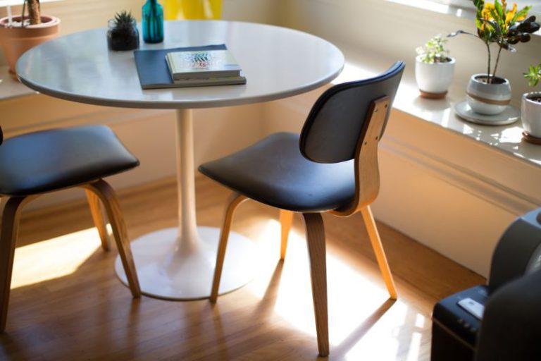 DIY Home Office - round white dining table beside two chairs on brown hardwood flooring
