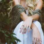 DIY Jewelry Organizer - woman sitting beside plant and concrete wall