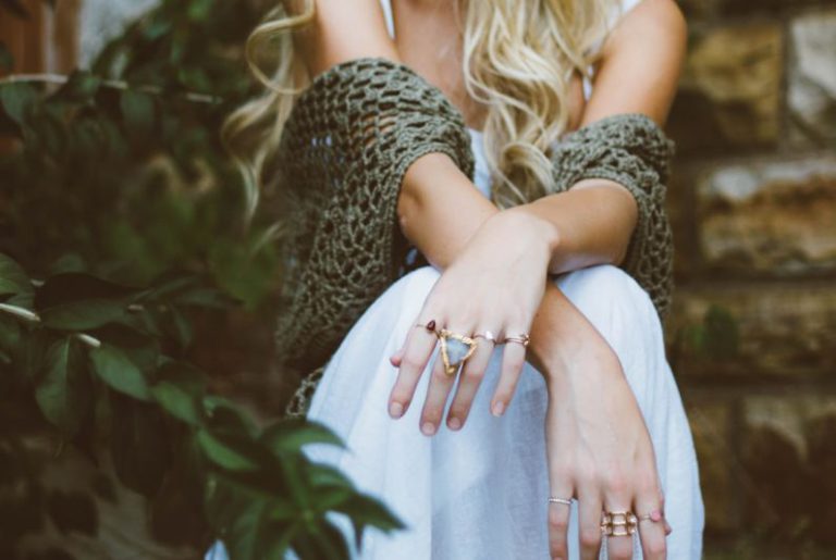 DIY Jewelry Organizer - woman sitting beside plant and concrete wall