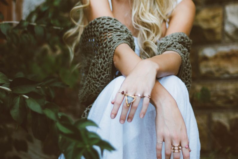 DIY Jewelry Organizer - woman sitting beside plant and concrete wall