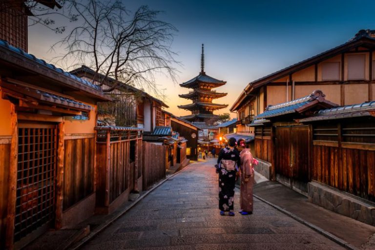 Solo Female Travel - two women in purple and pink kimono standing on street