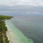 Exotic Beaches - an aerial view of a beach with boats in the water