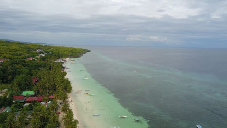 Exotic Beaches - an aerial view of a beach with boats in the water