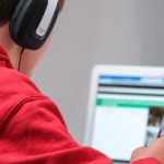 Online Learning - person in red shirt wearing black and gray headphones