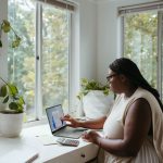 Remote Work - a woman sitting at a table with a laptop