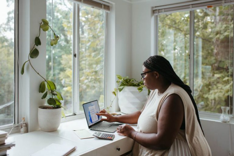 Remote Work - a woman sitting at a table with a laptop